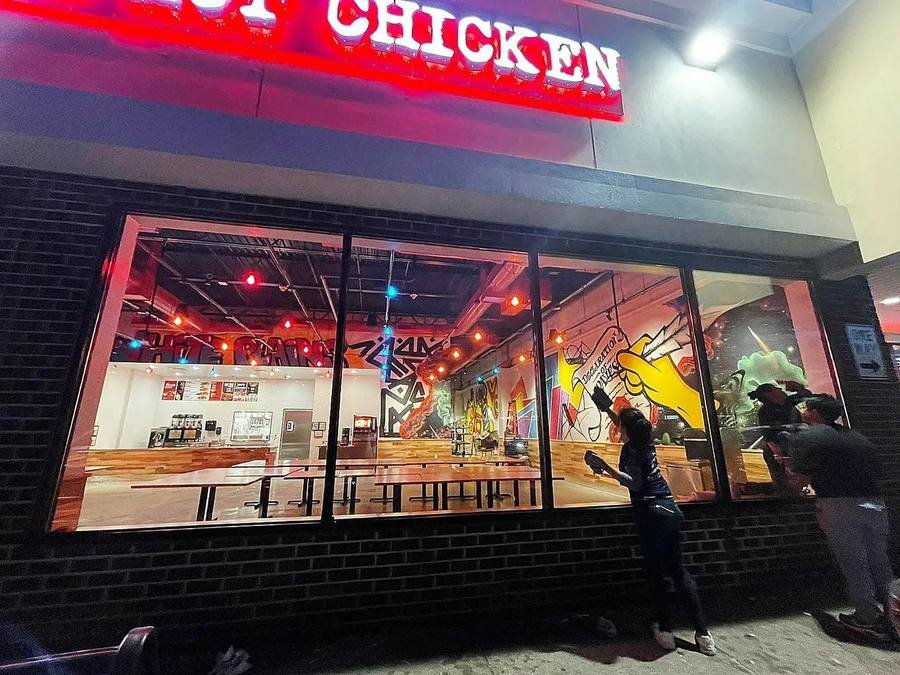 Cleaning restaurant storefront windows at night